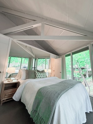 Wake up to a wall of green—this bedroom offers peaceful views of the surrounding woods