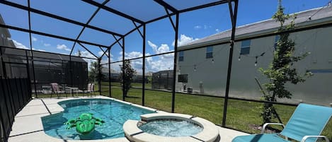 Dive into relaxation in our sunny screened-in pool oasis with a bubbling spa and playful alligator float-perfect for fun under the Florida sky!