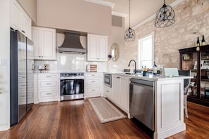 This luxurious kitchen features high-end stainless steel appliances, gleaming countertops, custom cabinetry, and is perfect for entertaining.