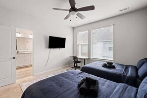Unwind in this spacious bedroom with two cozy beds, a mounted TV, and plenty of natural light. Enjoy the convenience of an en-suite bathroom and a dedicated workspace.