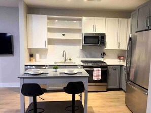  Experience the joy of cooking in this modern kitchen, where sleek countertops, state-of-the-art appliances, and plenty of storage make meal prep a breeze.