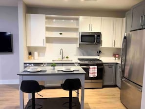 Experience the joy of cooking in this modern kitchen, where sleek countertops, state-of-the-art appliances, and plenty of storage make meal prep a breeze.