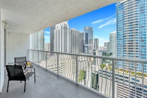 Private balcony with outdoor seating and stunning views of the bay and city skyline.