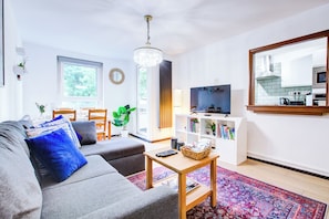A cozy sunlit living room with comfy and stylish touches.