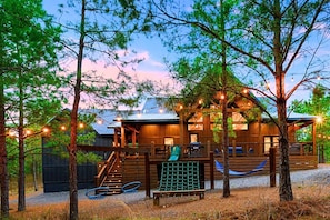 The outdoor play area has a tube slide, swings, climbing wall, and hammock
