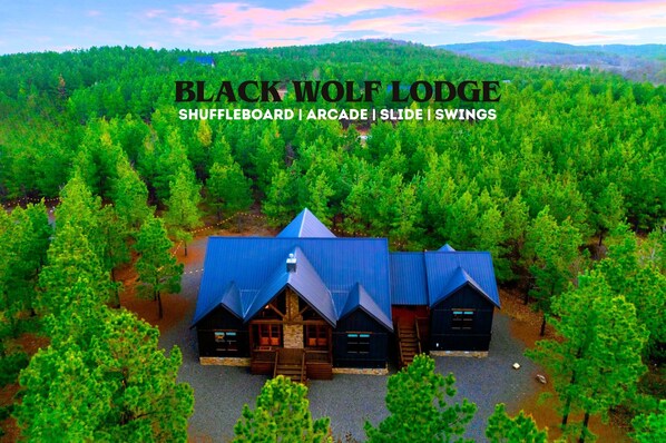 Cabin dreams come true: A forest escape with games, hammocks, and glowing string lights.