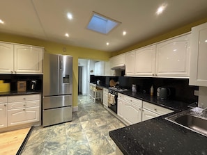 Well-Equipped Kitchen – Whether you're whipping up breakfast or preparing a full dinner, you'll find everything you need, including modern appliances, cookware, and utensils. It leads to the dining area and the conservatory.