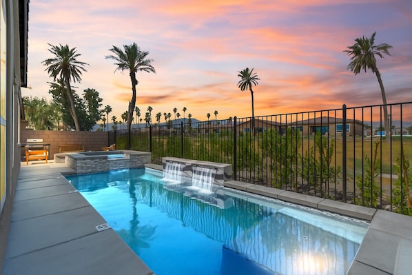Private pool with cascading waterfalls and mountain-view sunsets.