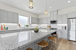 Spacious chef’s kitchen with oversized granite island and bar seating.
