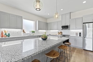 Spacious chef’s kitchen with oversized granite island and bar seating.