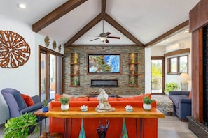 Open concept living space with plenty of natural light, comfortable seating, and a unique built-in waterfall feature for a relaxing ambiance.