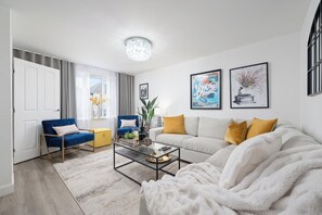 Stylish living room with plush seating, modern decor, smart tv & fire place
