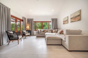 Open-concept living room with stylish furniture and large glass doors