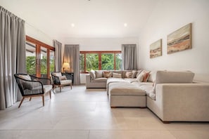 Open-concept living room with stylish furniture and large glass doors