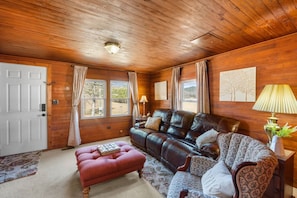 The living room includes plenty of comfortable furniture for the entire group.