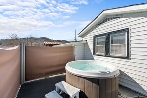 The back deck includes the relaxing hot tub. Retractable privacy screens are included.