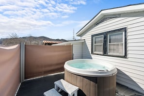 The back deck includes the relaxing hot tub. Retractable privacy screens are included.