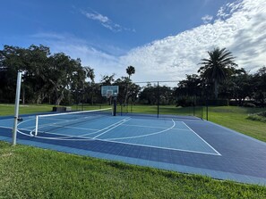 Sport court with pickle ball, basketball, and batting cage