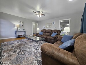 The door on the left leads to two bedrooms and the bathroom. The door on the right leads to the kitchen and dining area.