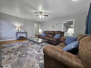 The door on the left leads to two bedrooms and the bathroom. The door on the right leads to the kitchen and dining area.
