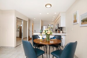 LOK-B201 Dine beside ocean blues in this airy nook where sleek chairs, fresh florals, and seaside sunshine set the tone