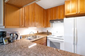 KUL-E113 Where golden cabinetry meets granite sparkle?this cozy culinary cove invites you to brew, bake, or just bask