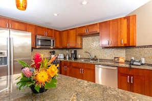 HKH-423 Chef-ready kitchen with granite countertops, stainless appliances, and a floral island welcome centerpiece