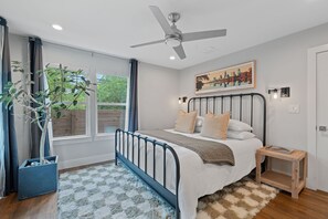 Relax in the spacious primary bedroom featuring a plush king bed, soft linens, and a calming atmosphere—perfect for a restful night after a day exploring Austin.