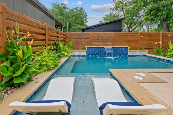 Step outside to enjoy the private fenced-in backyard, complete with outdoor seating and a sparkling pool (please note: the pool is not heated).