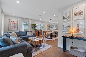 The open-concept living area features reclaimed hardwood floors, cozy seating, and a welcoming ambiance ideal for relaxing after a day of exploring or enjoying quality time with friends and family.