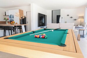 Salle à manger élégante avec une table modulable se transformant en table de billard.
