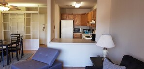 The living room comes furnished with essential pieces, including a comfortable sofa, a coffee table, and a TV stand, providing immediate comfort upon move-in.