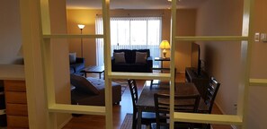 The living room comes furnished with essential pieces, including a comfortable sofa, a coffee table, and a TV stand, providing immediate comfort upon move-in.