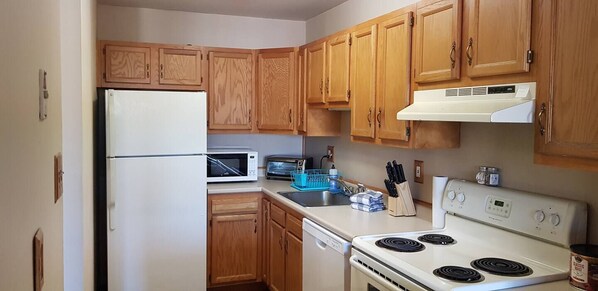 Step into a well-appointed kitchen designed for convenience. It includes a full-sized refrigerator, range, and plenty of counter space for meal prep. You'll find generous storage in the cabinetry, making it easy to keep things organized.