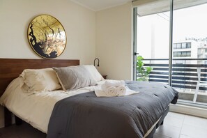 Cozy bedroom with balcony access, perfect for enjoying city views and relaxation.