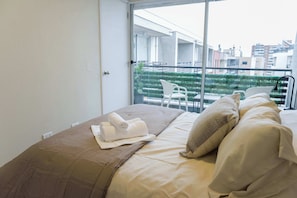 Cozy bedroom with city views and a private balcony, perfect for a relaxing stay in the heart of Chile.
