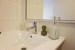 Modern bathroom with sleek fixtures and a touch of greenery for a refreshing start to your day.