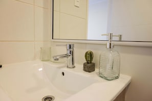 Modern bathroom with sleek fixtures and a touch of greenery for a refreshing start to your day.