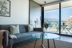 Relax in a chic living room with stunning city and mountain views from the spacious balcony.
