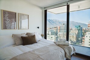 Wake up to breathtaking city and mountain views in this serene bedroom retreat, perfect for a relaxing stay in the heart of Chile.