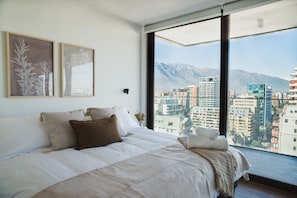 Wake up to breathtaking city and mountain views in this serene bedroom retreat, perfect for a relaxing stay in the heart of Chile.