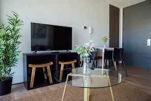 Relax in this stylish living area with a sleek TV setup and cozy dining nook, perfect for unwinding after a day of exploring.