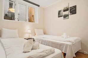 Light-filled bedroom with two single beds, perfect for friends or children.