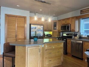 Kitchen has island that seats 4, stainless appliances, gas convection  range.