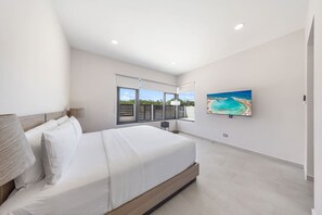 This is Master Bedroom 1, located on the first floor—bright, spacious, and designed for comfort. Enjoy a restful night in a cozy king bed, with large windows letting in the island breeze and a TV ready for laid-back movie nights.