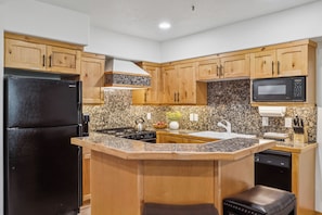 Gourmet kitchen with granite countertops and wood cabinetry.