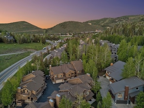Aerial view of the home nestled in the trees and mountains.