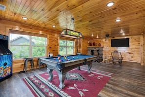 Game room featuring a pool table, arcade game, cozy seating, fireplace, and TV for endless entertainment.