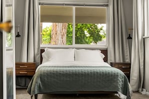 Spacious first bedroom featuring a plush queen bed