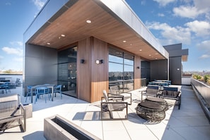 Communal Area: A stylish rooftop lounge area featuring a pool table, multiple dining spaces, and cozy spots to relax and unwind.